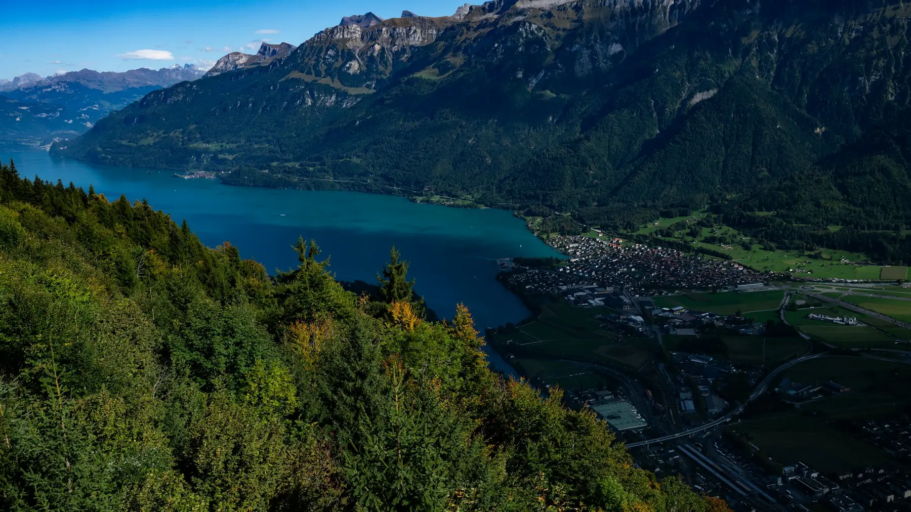 Lago entre montanhas com um vilarejo na margem