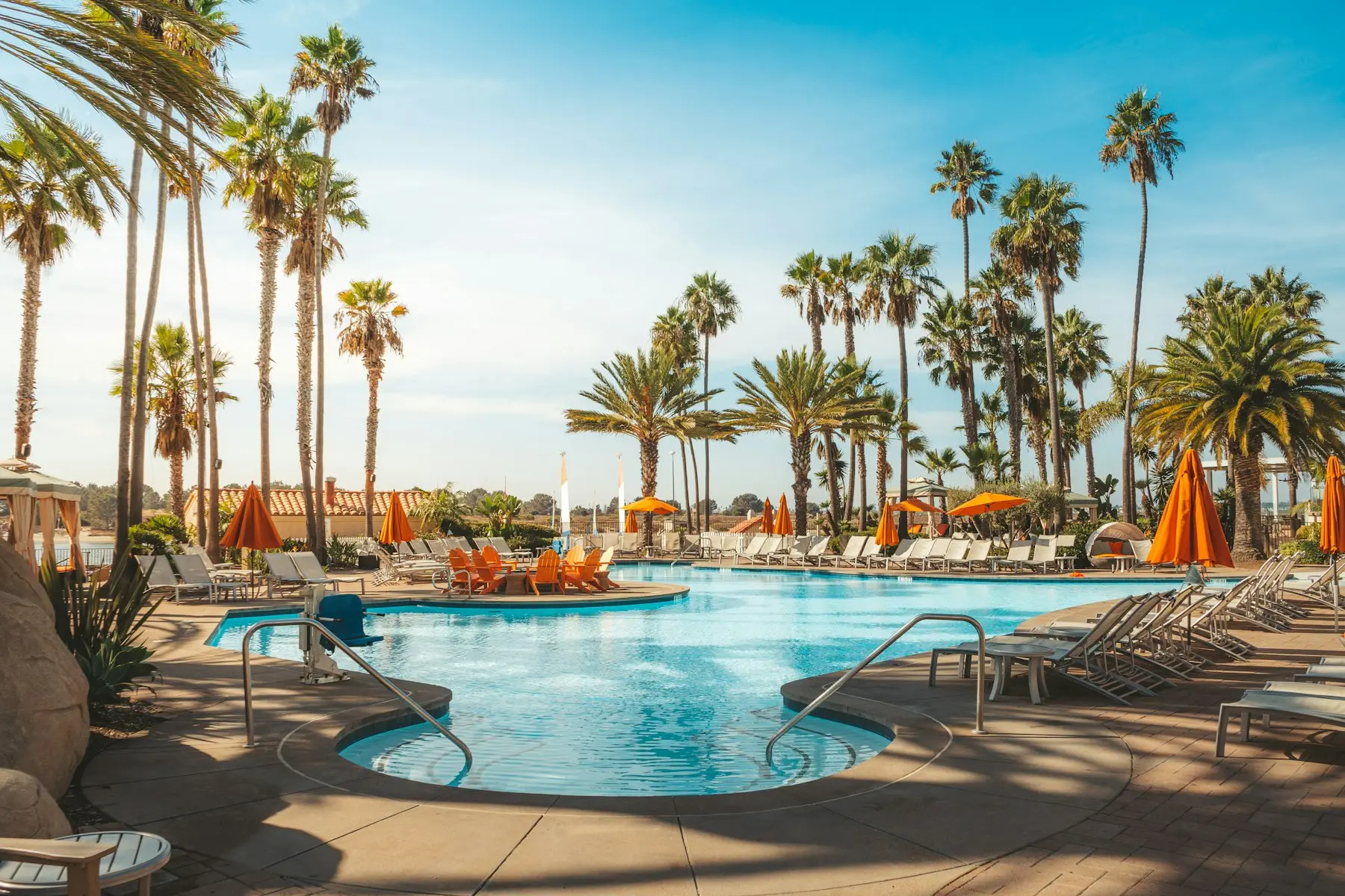 Piscina cercada de coqueiros em um resort